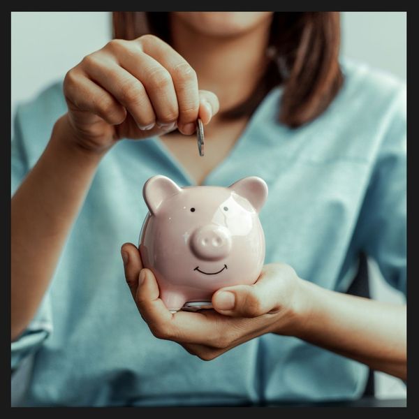 Women putting money into a piggy bank