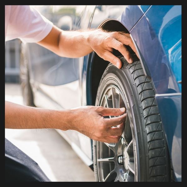 A mechanic putting air into a tire