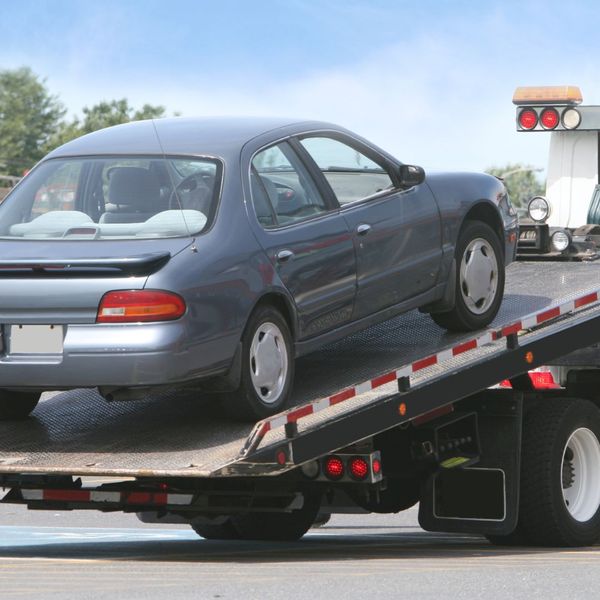 Nissan being loaded onto a flatbed