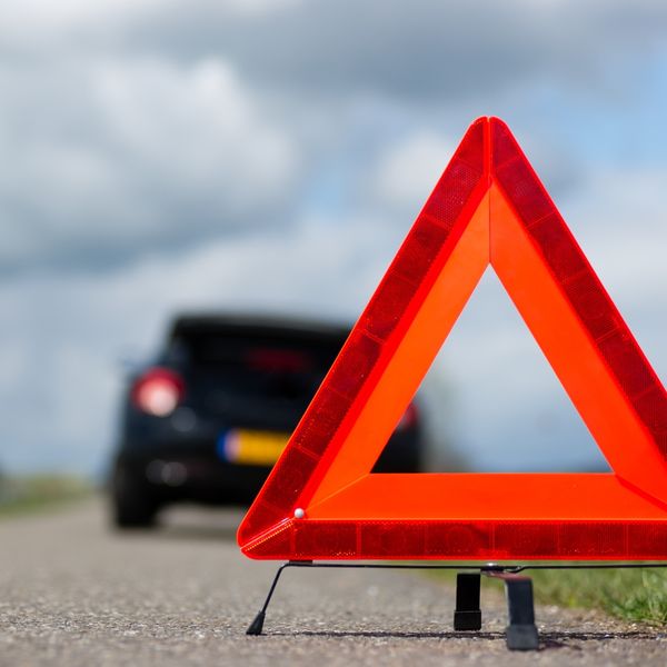 Warning triangle behind a car parked roadside