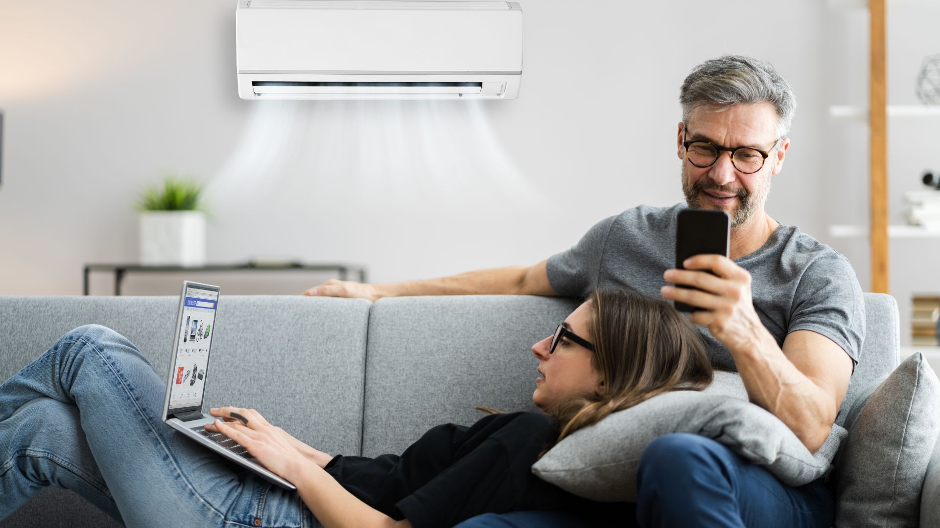 couple relaxing on couch with air conditioning