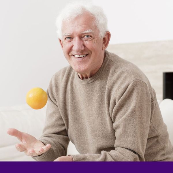 older man tossing apple in the air