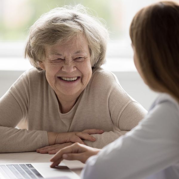 Woman smiling with younger woman on a laptop