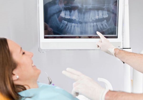 doctor going over dental x-rays with patient
