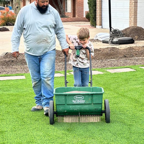 Kid mowing lawn with adult