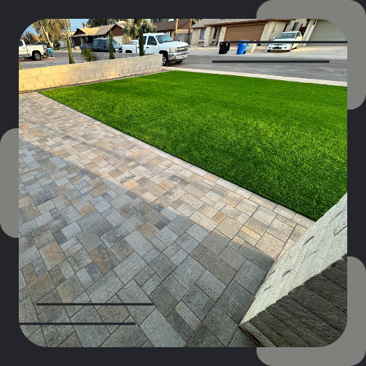 Paver patio next to green artificial turf.