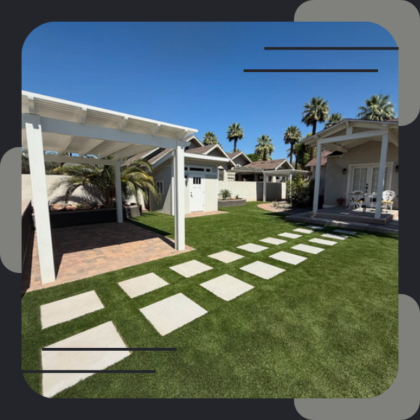 Paver patio with pergola next to green artificial turf.