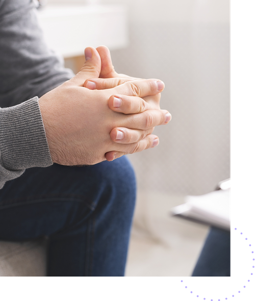 Image of a man in a therapy session with interlaced fingers