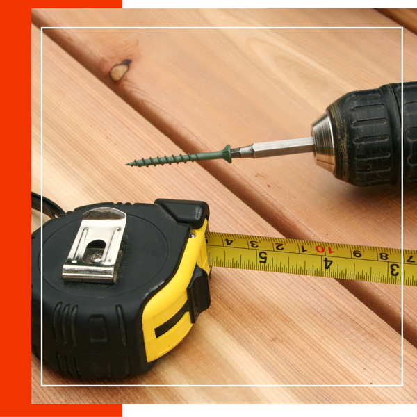 a drill and a tape measure on a newly built deck. 