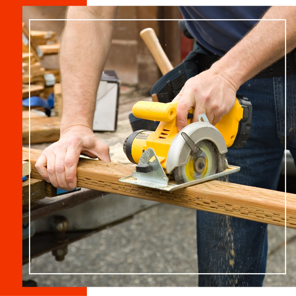 person sawing a piece of lumber. 