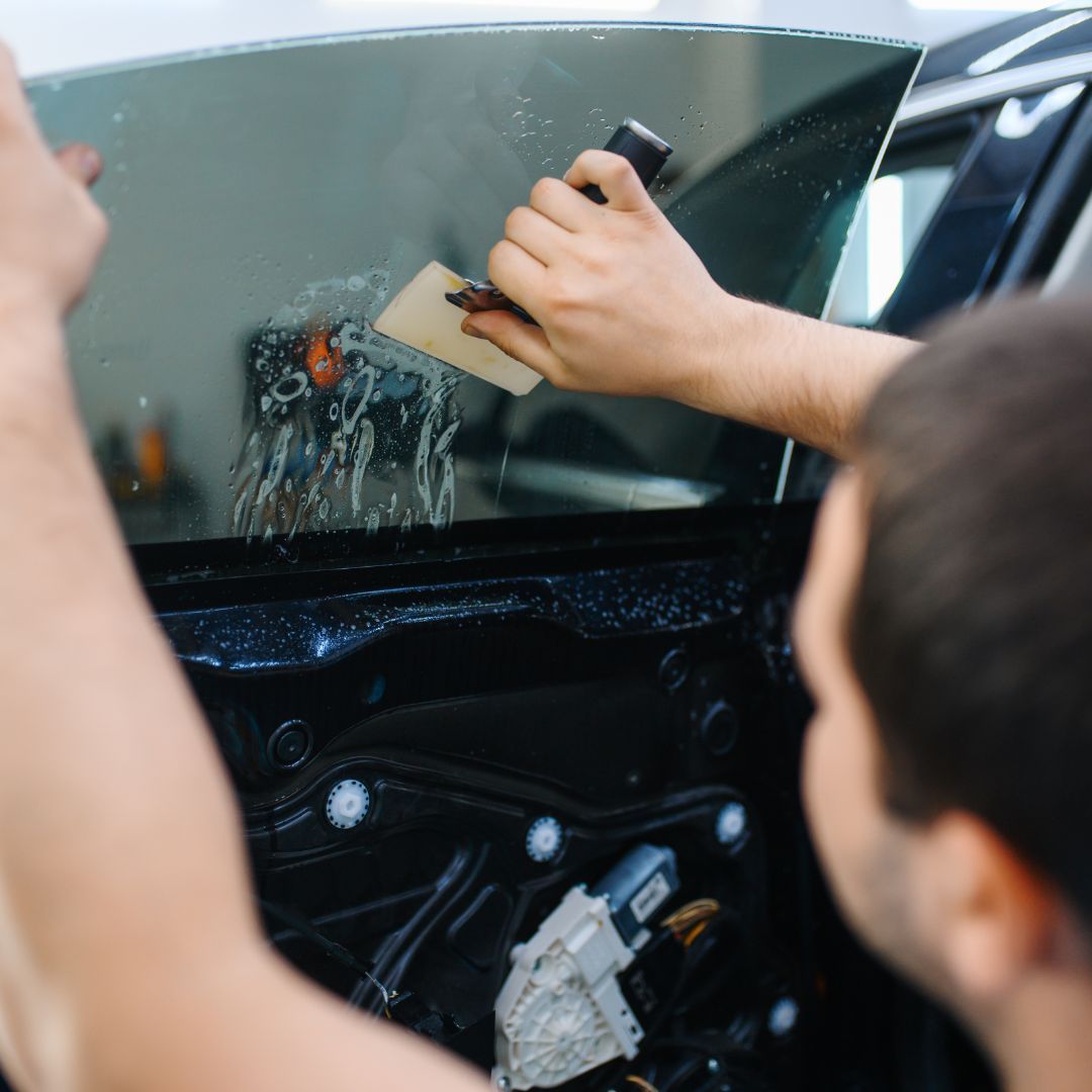 A man applies carbon window tinting