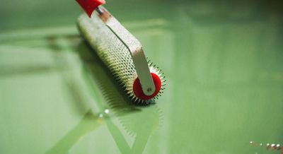 green epoxy being spread using a roller