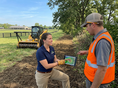 Land management professionals discussing plans with a tablet