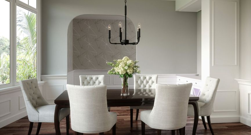 Black 5-light candelabra chandelier hanging over a dark wood dining table with white tufted chairs and fresh hydrangeas. Black 5-light candelabra chandelier hanging over a dark wood dining table with white tufted chairs and fresh hydrangeas.