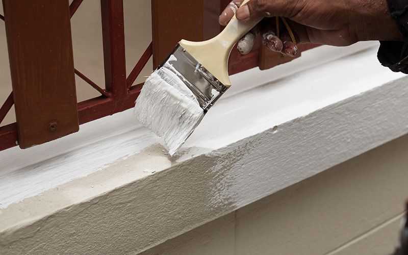 close up of someone painting a window sill
