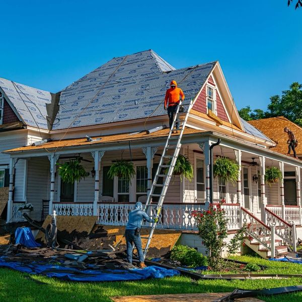Roofers clearing a roofs shingles 
