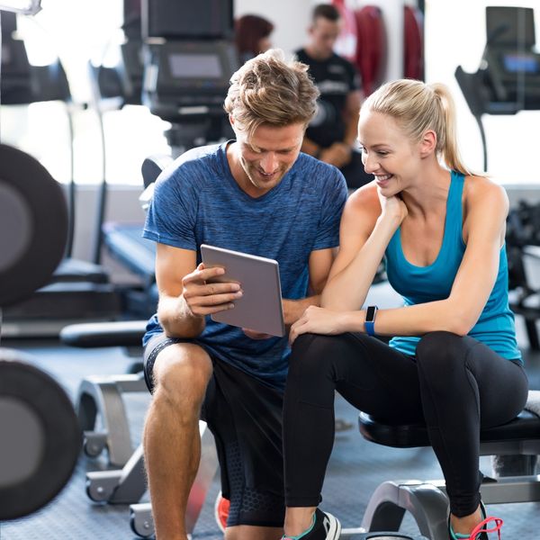 Trainer pointing at tablet with client