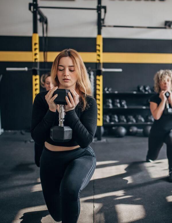 people lifting weights in fitness class