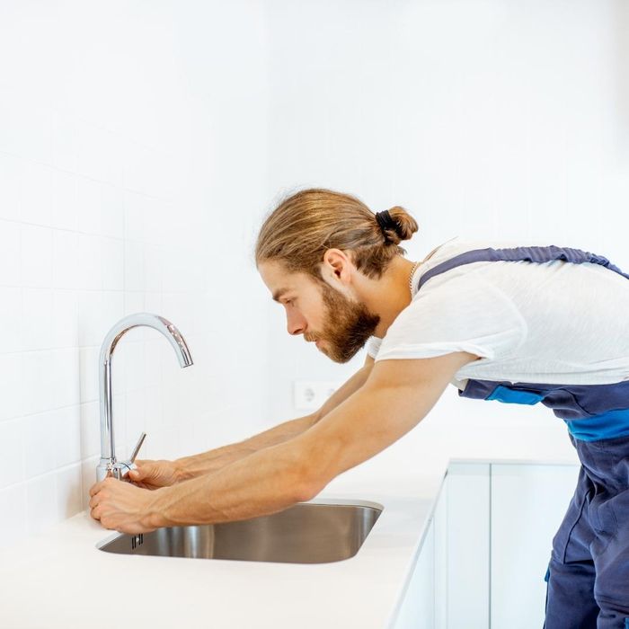 A plumber replacing a faucet