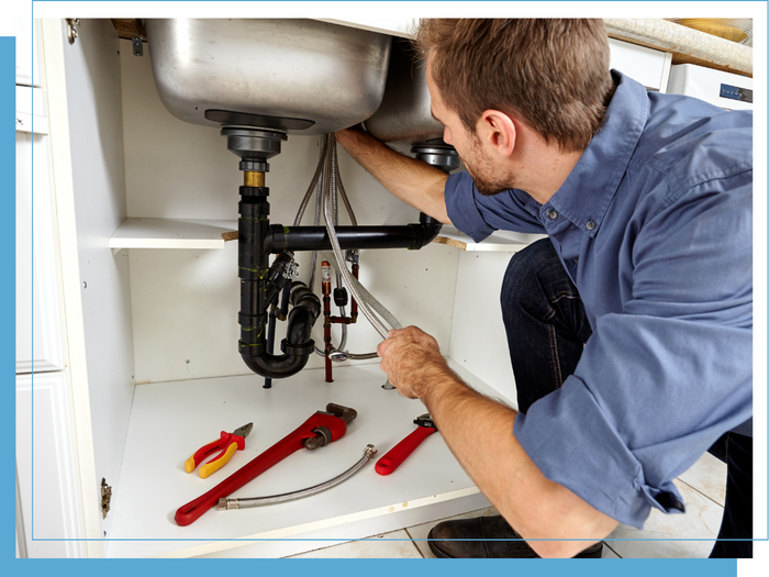 male plumber working underneath a sink