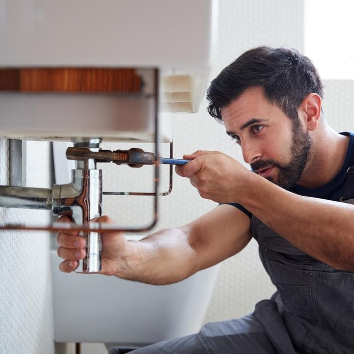 A plumber repairing a faucet