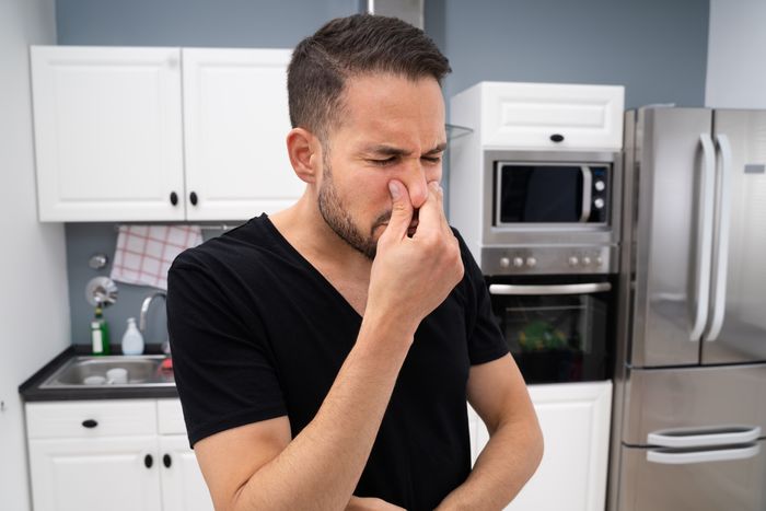 The smell from the sink making a man pinch his nose