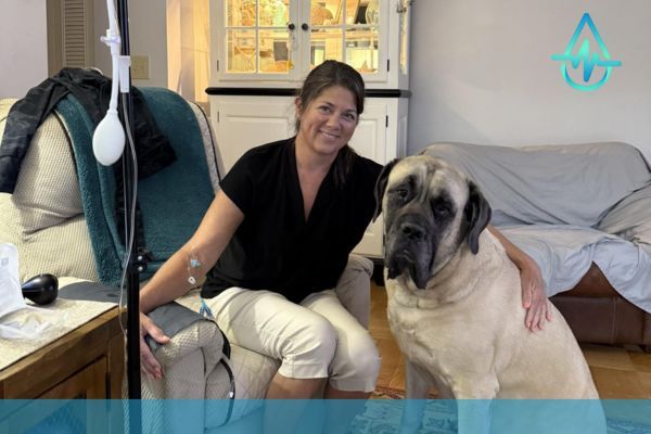happy woman getting IV drip in own home, hugging large dog