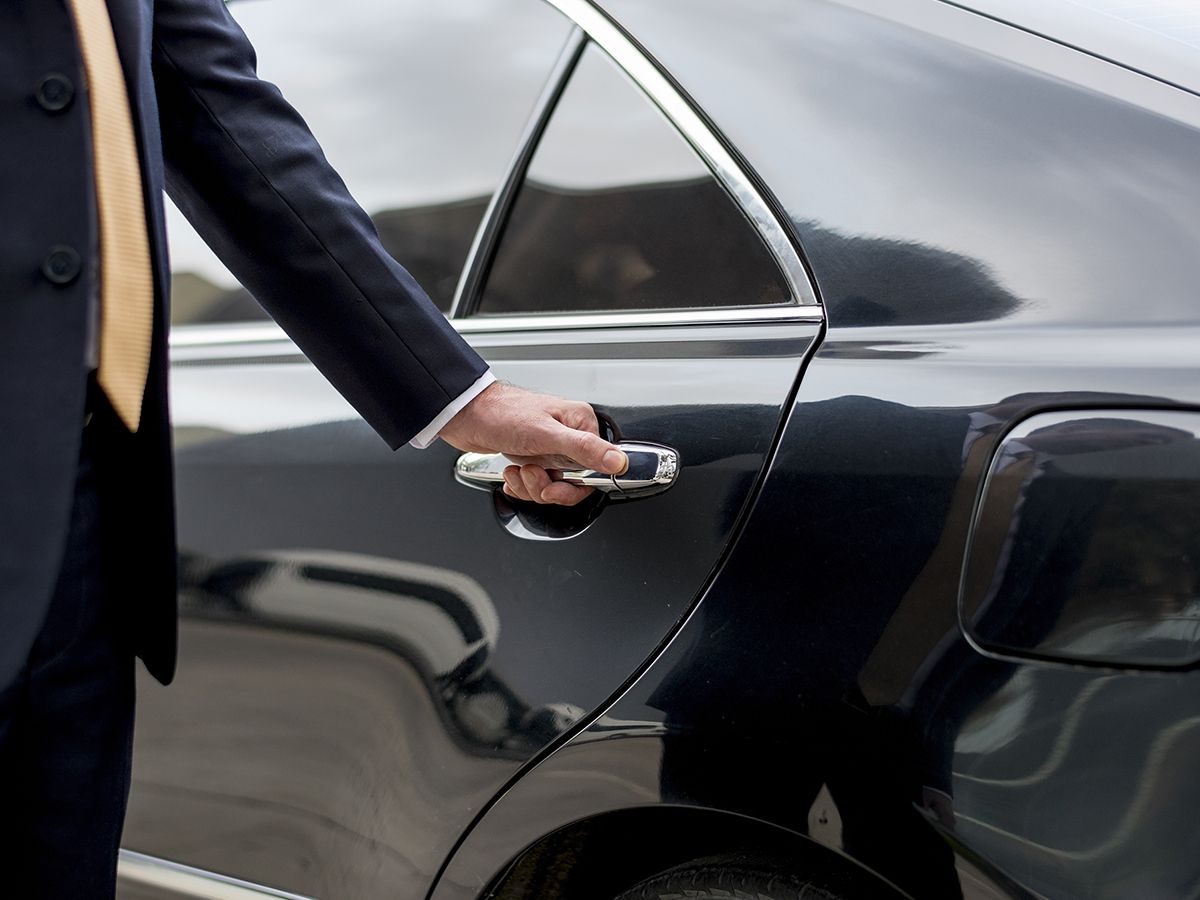 man in suit with luxury vehicle