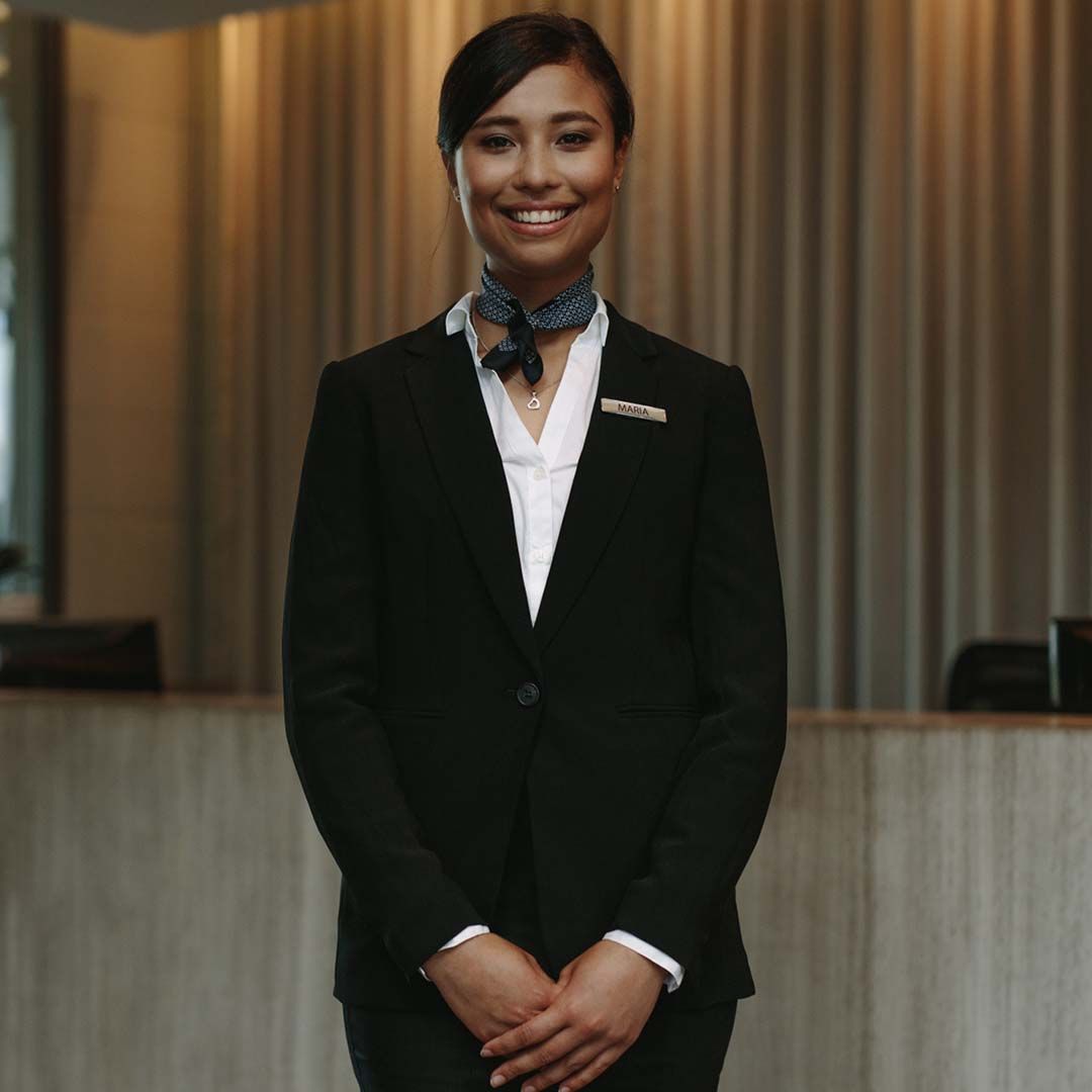 Woman wearing business clothing, smiling. 