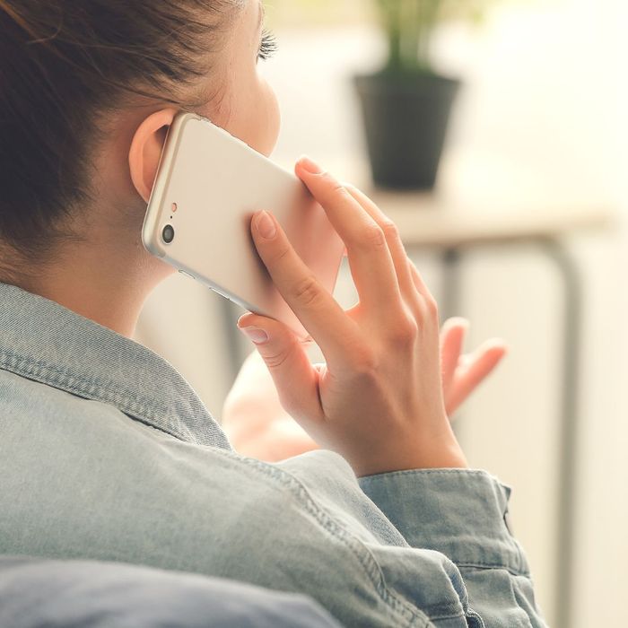 close up of woman holding cellphone to ear