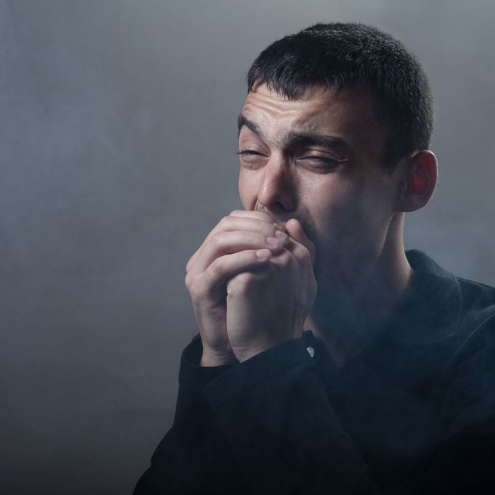 man coughing from smoke inhallation 