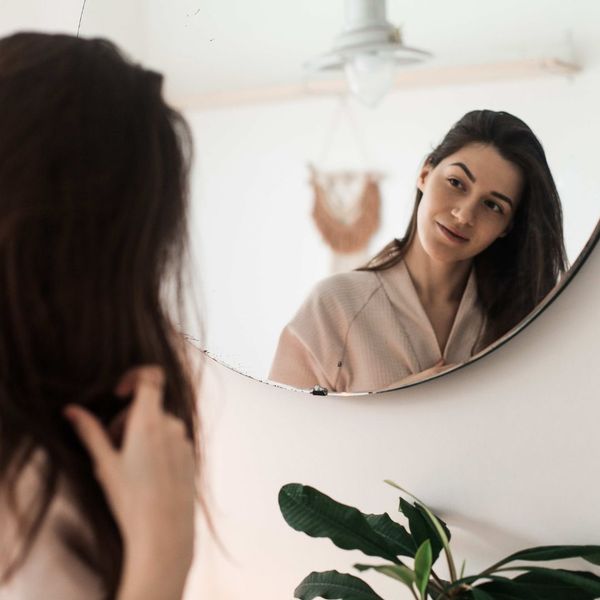 a woman smiling in the mirror The Role of Antioxidants in Cellular Health (2).jpg