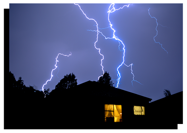 photo of a house with lights up during a lightning storm