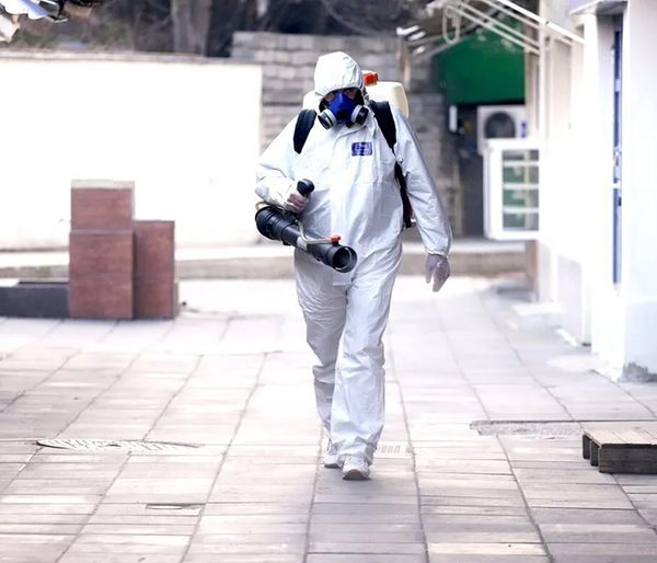 Image of a person disinfecting an area