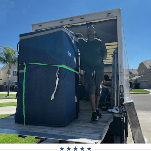 mover standing alongside a large item that he has wrapped for a move