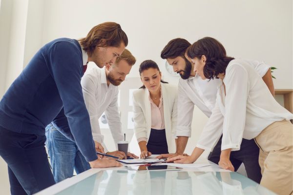 people looking at papers over a table Course Overview_1.jpg