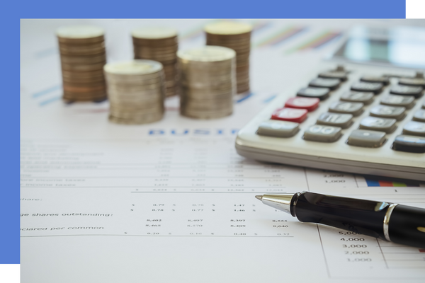 calculator and coins stack on top of paperwork