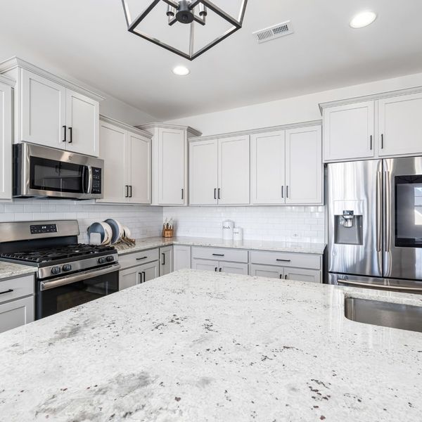 clean kitchen with white cabinets and countertops