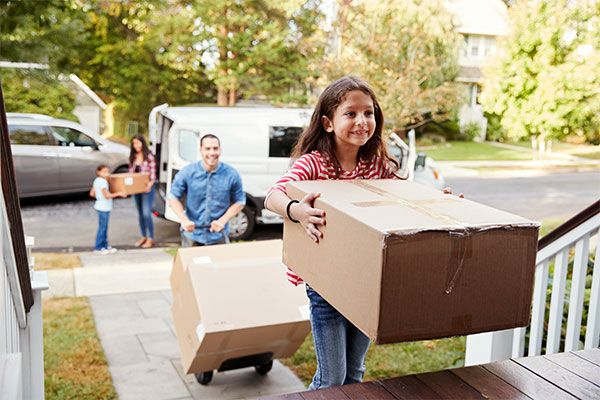 Family moving boxes into new house