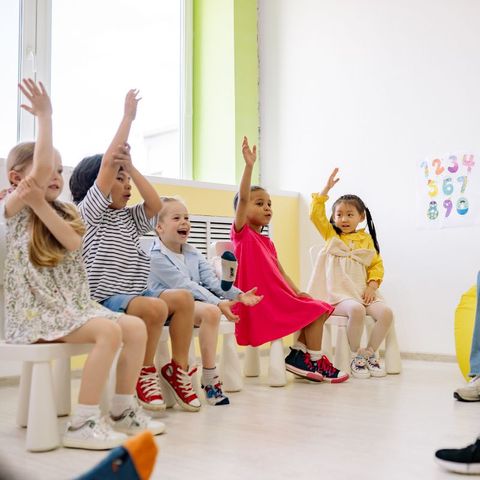 kids raising their hands to answer a question