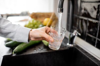 filling drinking glass with tap water