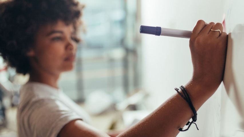 Woman writing on white board Woman writing on white board