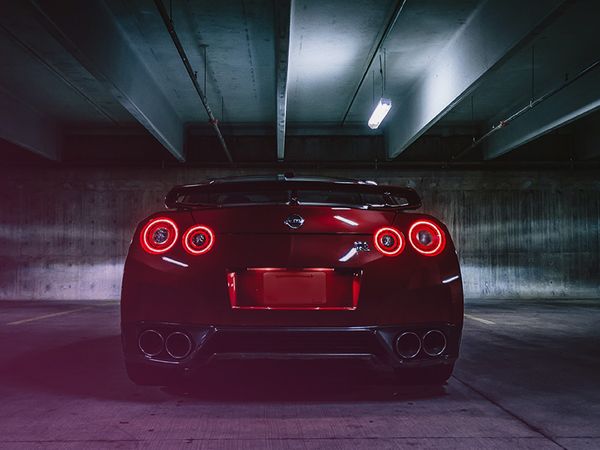 photo of the back end of a sports car in a parking garage