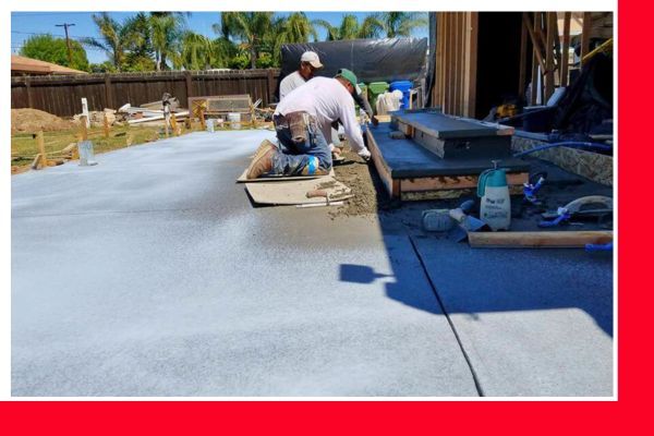Concrete workers in various stages of finishing a newly poured concrete slab next to a building under construction, with tools visible. Concrete workers in various stages of finishing a newly poured concrete slab next to a building under construction, with tools visible.