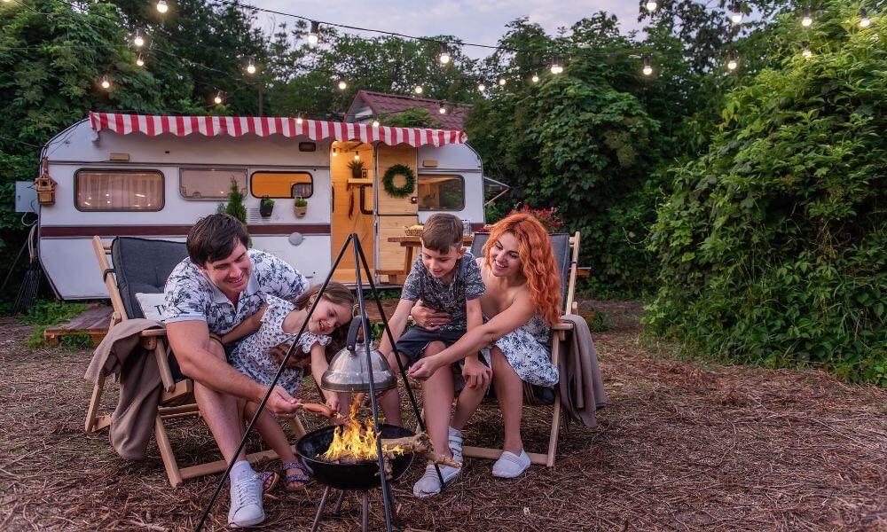 happy family gathered around firepit in front of rv