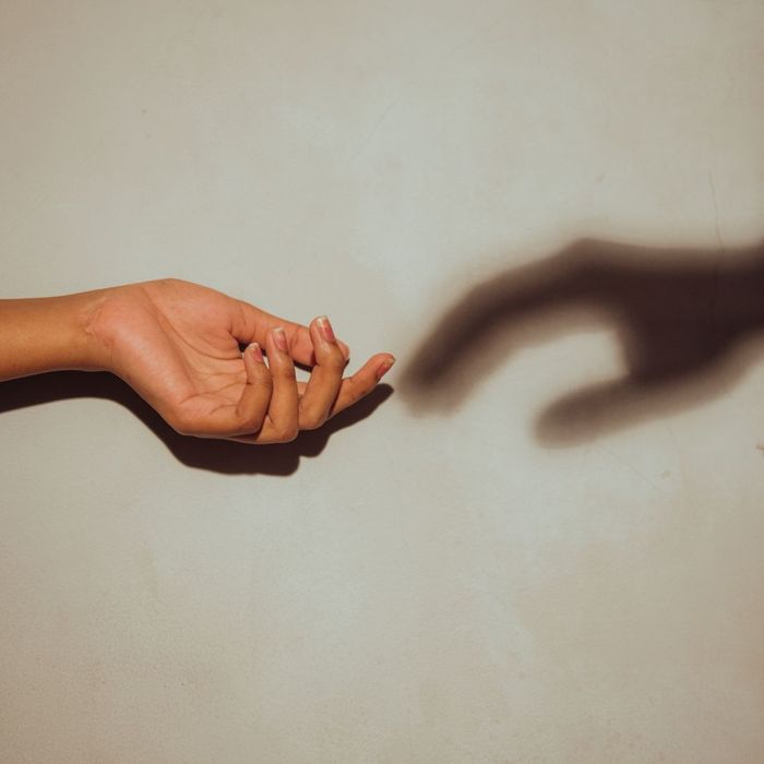 A hand silhouette, then a shadow of a hand, looking to grab each other