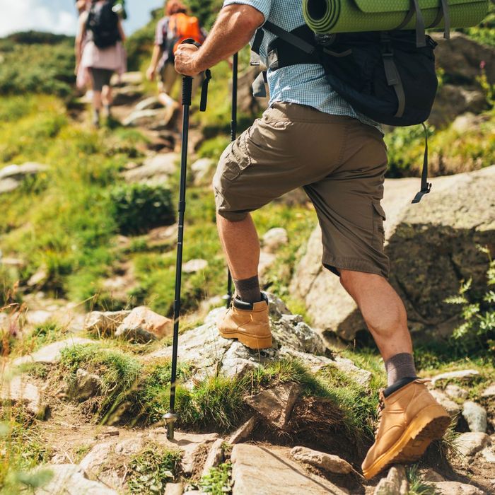 person hiking with trekking poles