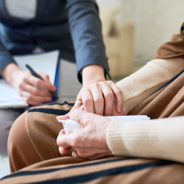 therapist holding hand of a person holding a tissue