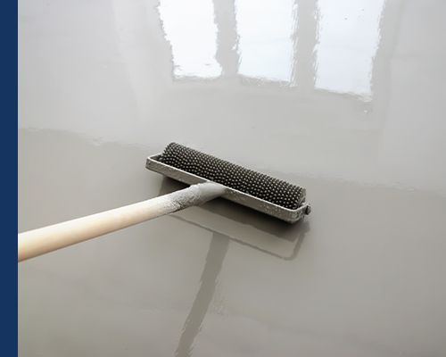 Image of self-leveling epoxy being applied with a roller brush.
