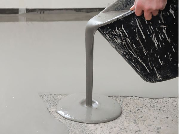 Applying self-leveling epoxy to a cement floor.